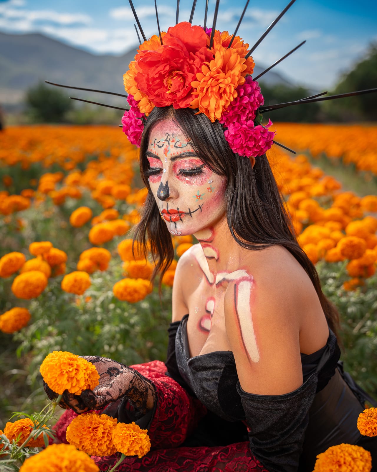 Catrina sentada entre flores de cempasúchil