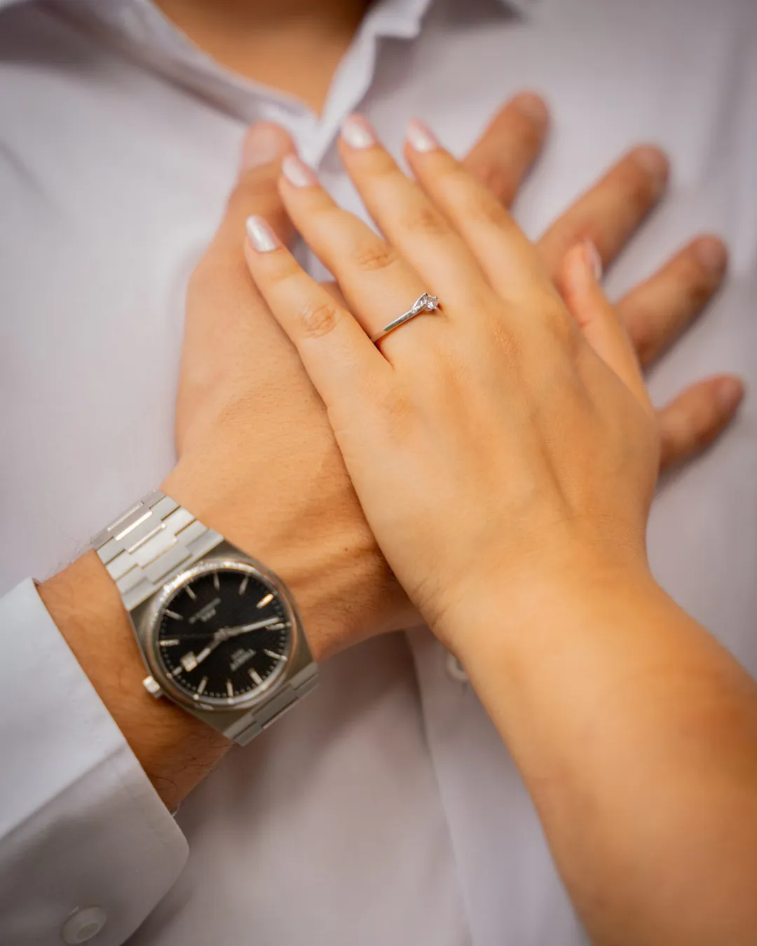 Manos con anillo de compromiso sobre el pecho